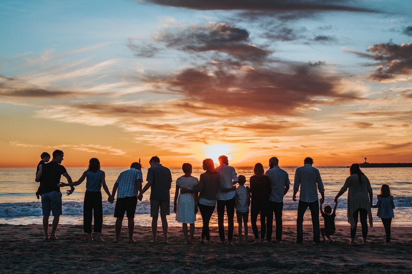 A family walking together on the beach at sunset